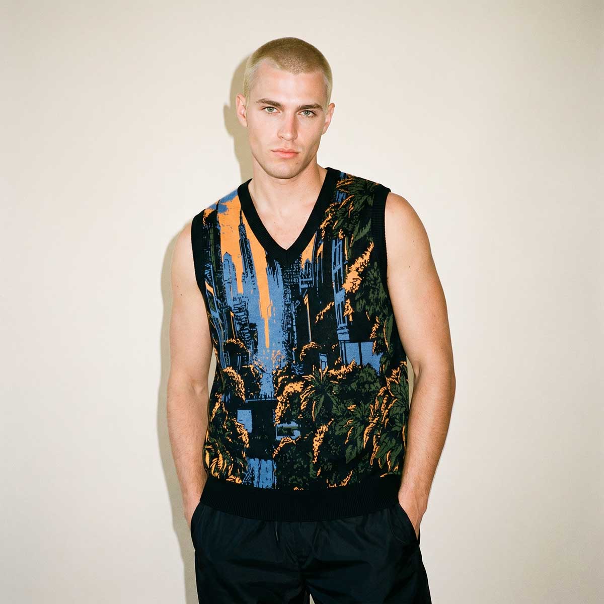 Man wearing a sleeveless patterned shirt against a plain background