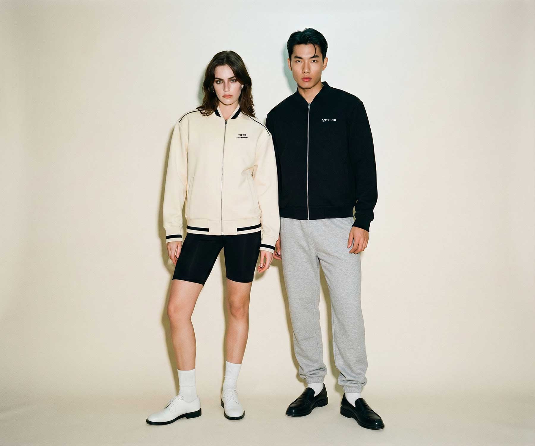 Two people wearing stylish outfits on a plain background