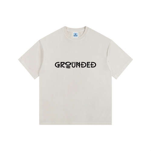 Beige t-shirt with 'GROUNDED' text on a white background