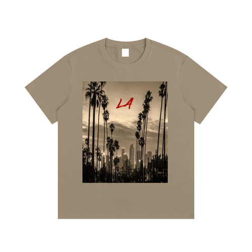 Beige t-shirt with a graphic of palm trees and a city skyline on a white background