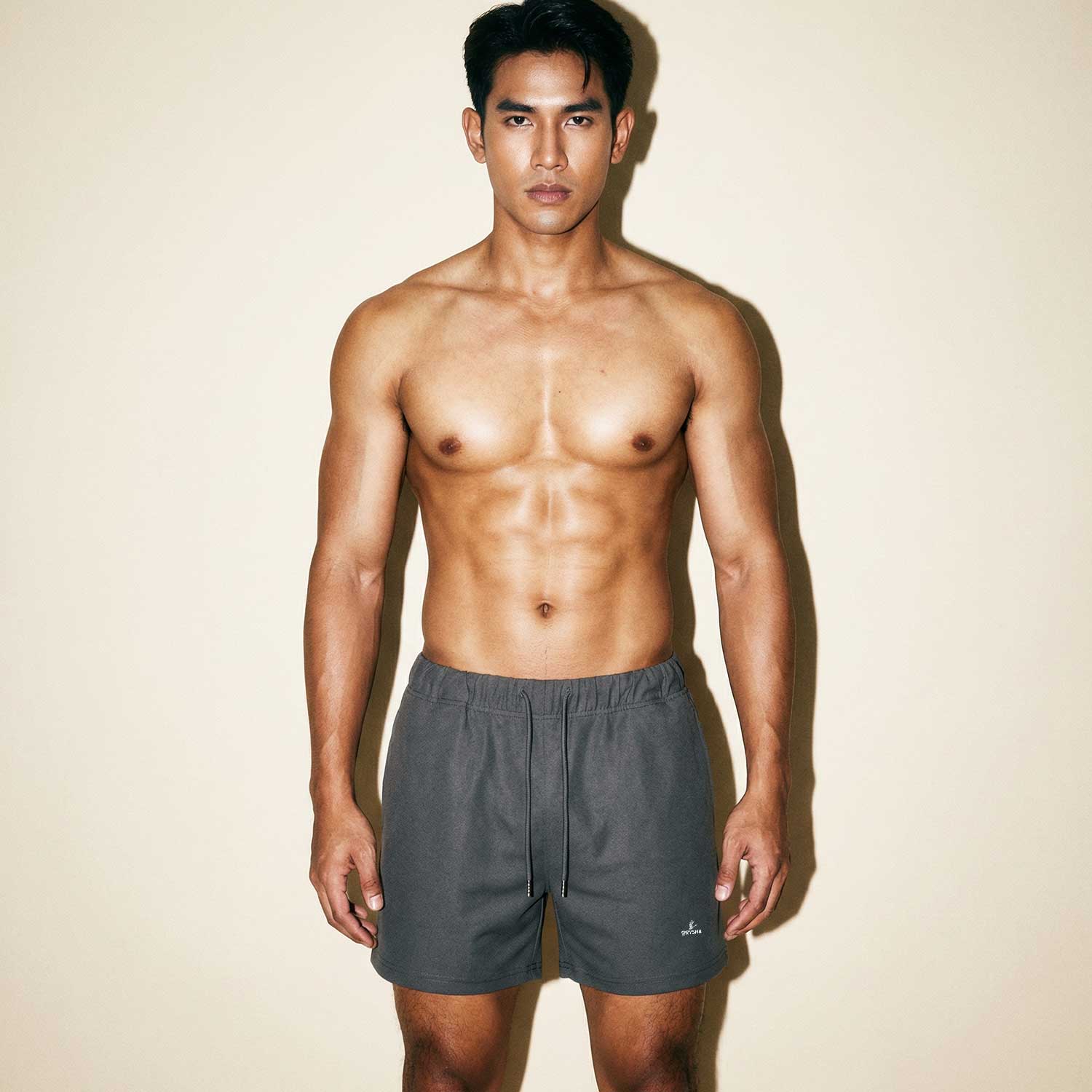 Man wearing Orysha men’s grey athletic shorts with a minimalist design and elastic waistband, styled for modern streetwear and casual comfort